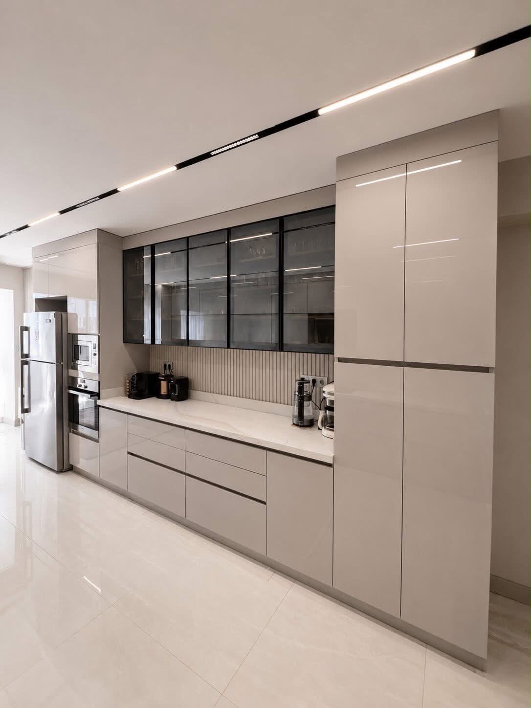 Modern galley kitchen with beige cabinets and linear recessed ceiling lighting