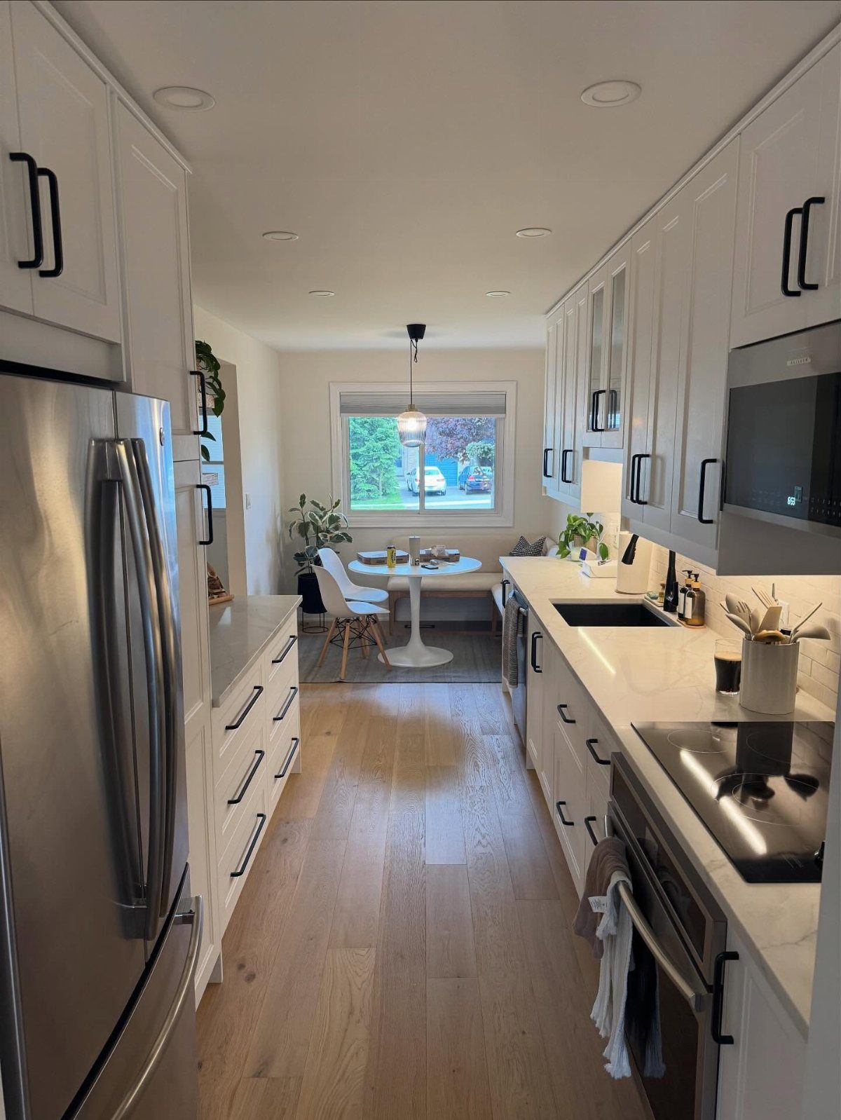 Galley kitchen with white cabinetry and circular recessed lighting in the ceiling