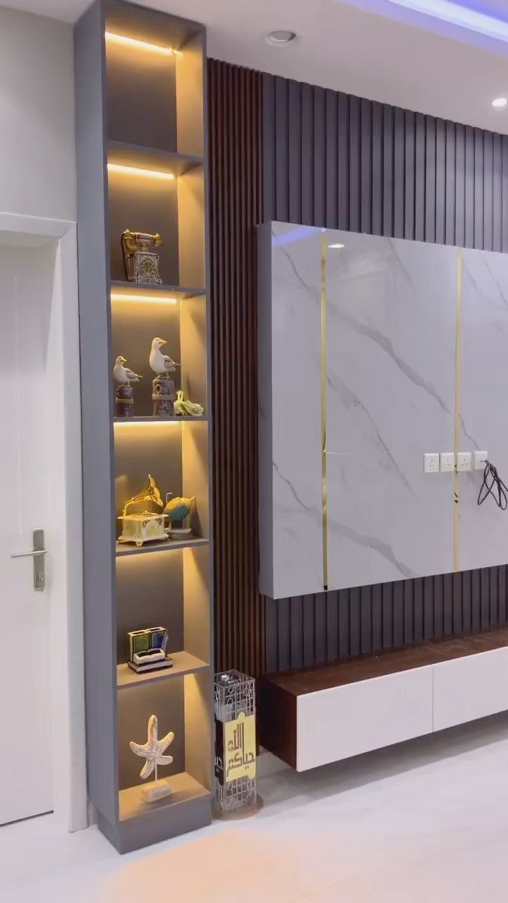 Grey built-in shelving unit with warm lighting and decorative objects in a modern room.