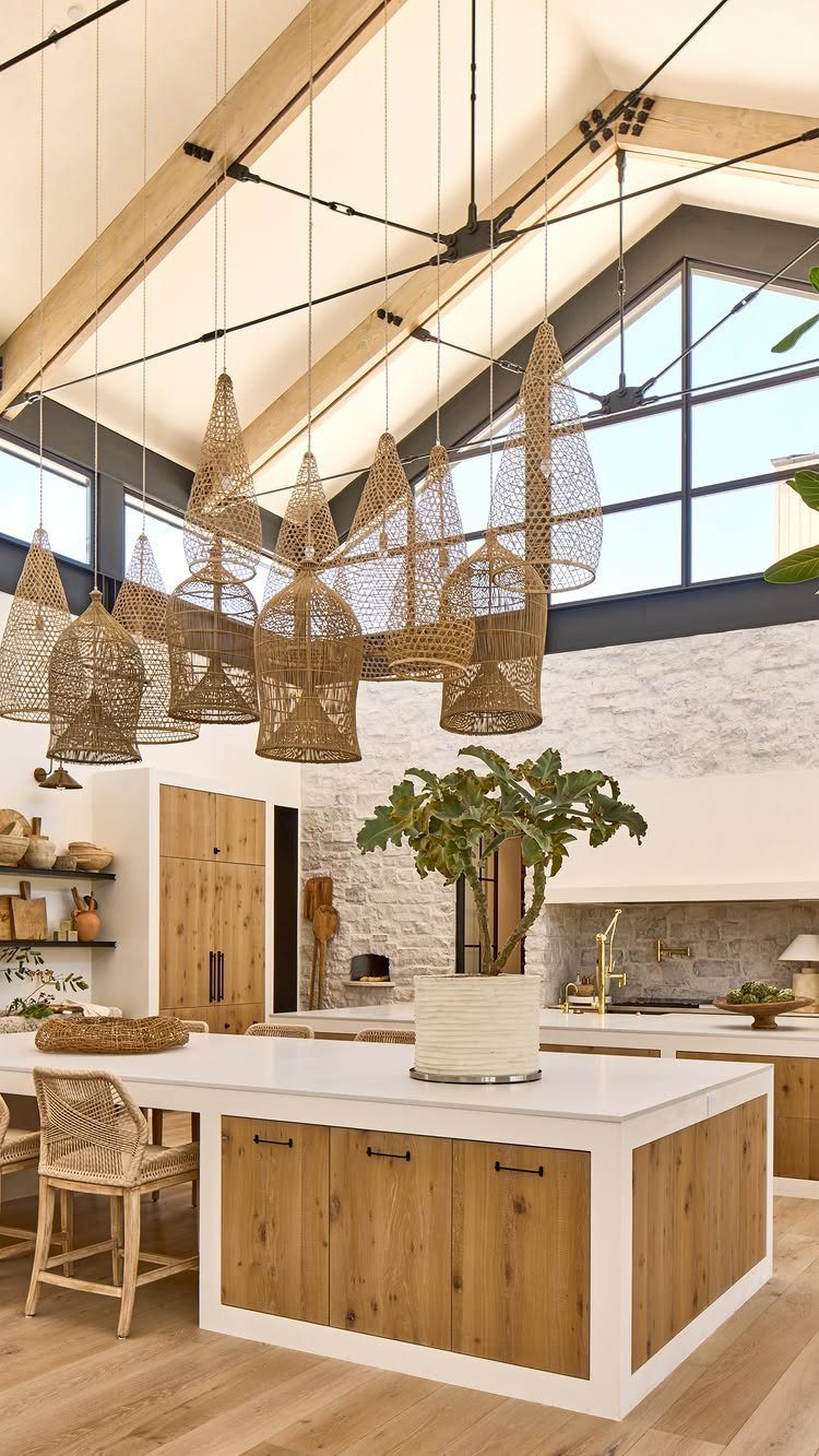 Modern farmhouse kitchen with white marble island and many woven wicker pendant lights.