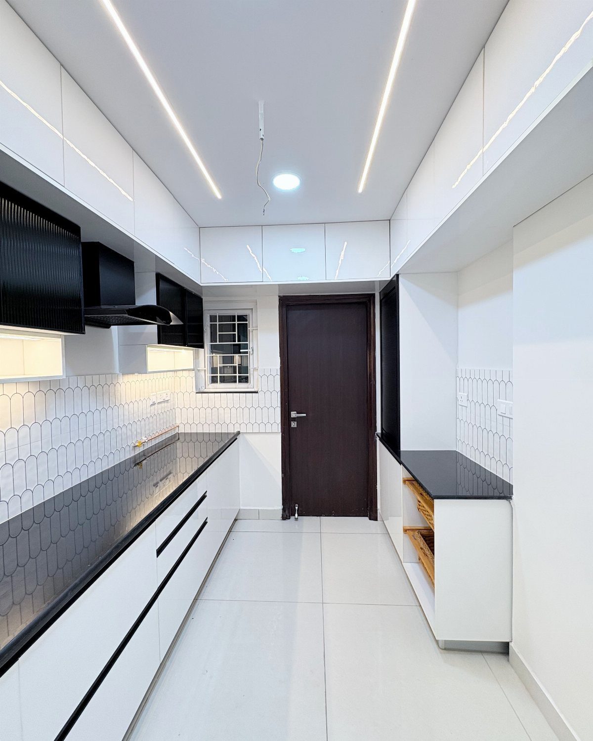 Modern kitchen with white cabinets, black countertops, and white tiled backsplash.
