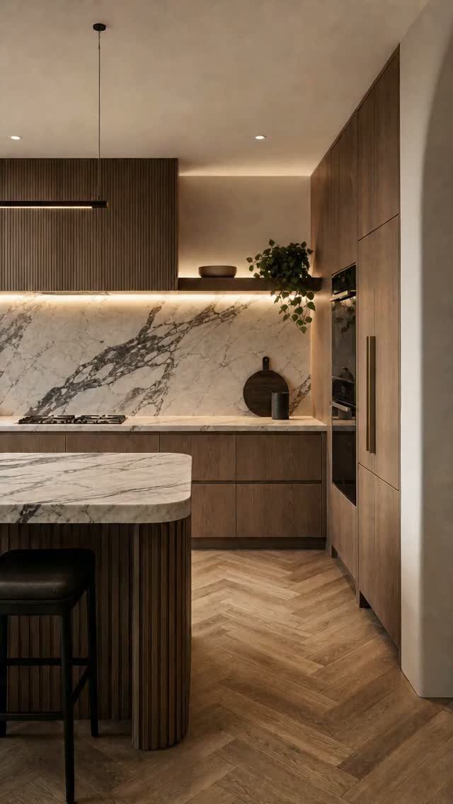 Modern wooden kitchen cabinets with marble countertops and herringbone wood floors.