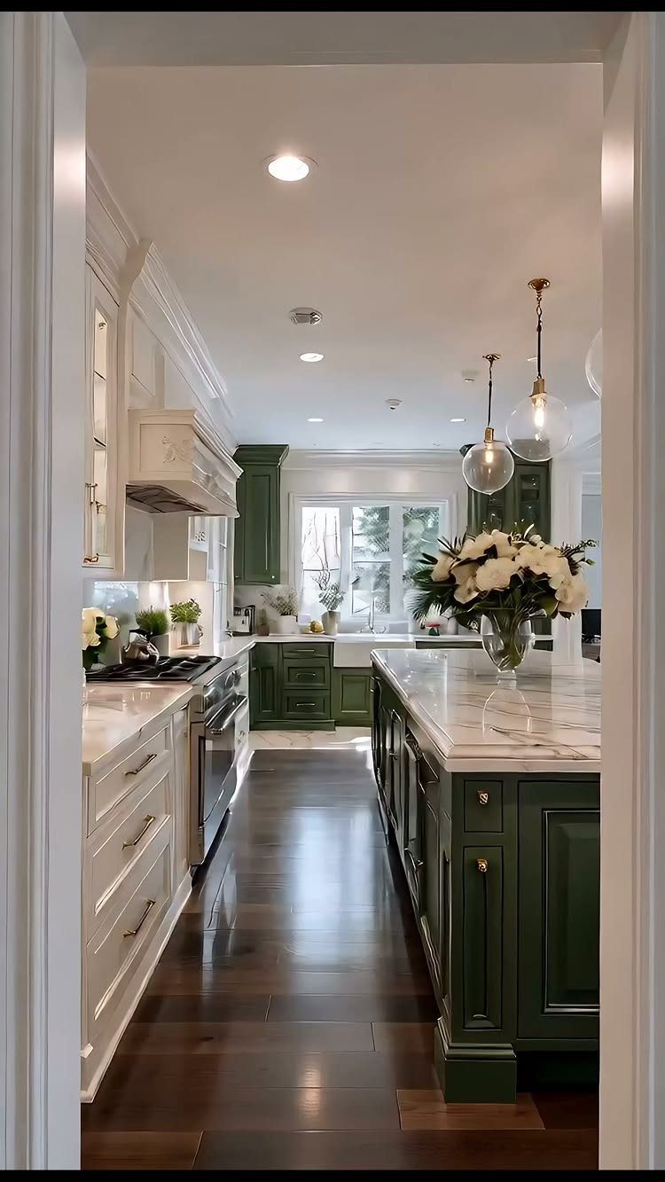 Two-tone kitchen with moss green base cabinets and white upper cabinets and marble countertops