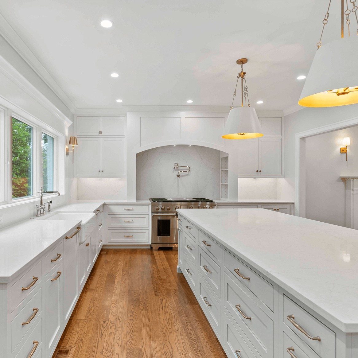 White kitchen with a light stone backsplash and large white center island.