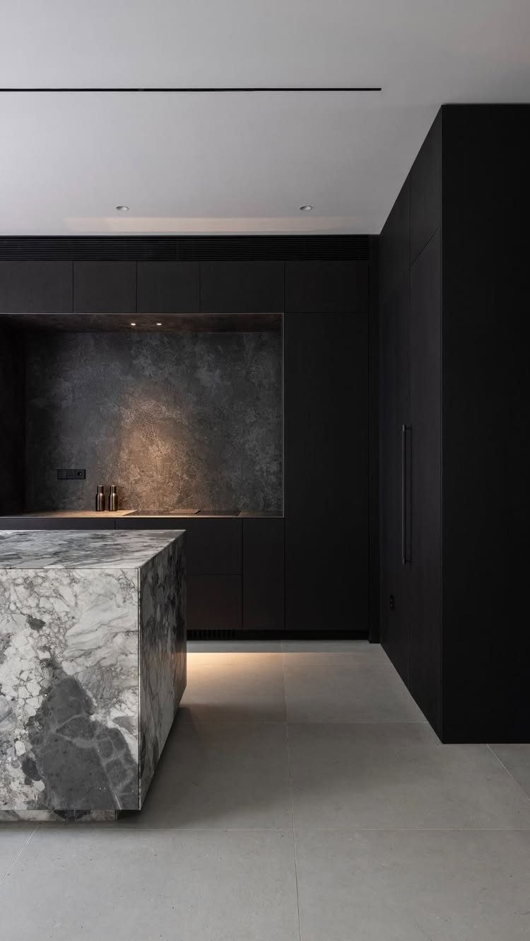 Dark grey granite slab backsplash and countertop in a minimalist black kitchen