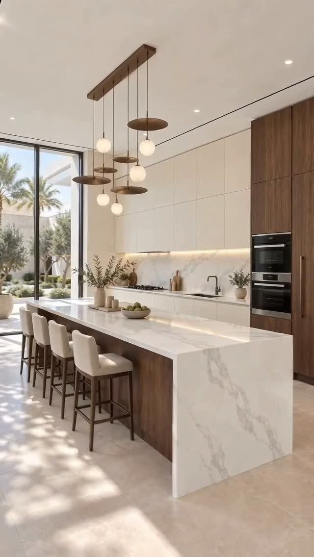 White marble waterfall island and countertops paired with natural wood kitchen cabinetry.