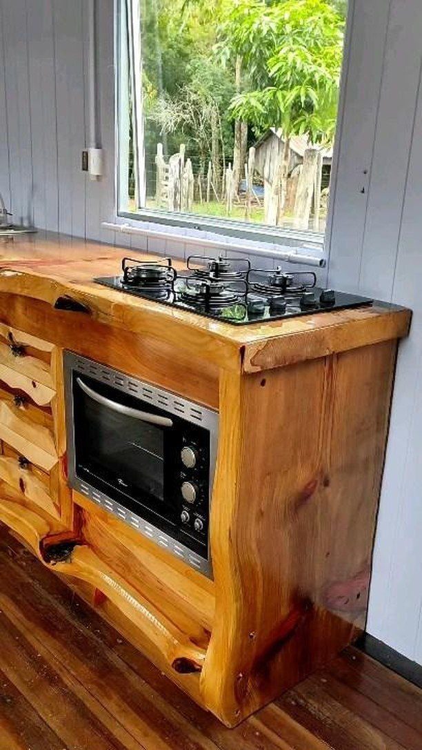 Natural wood kitchen cabinets with live edges, a gas stovetop, and built-in oven.