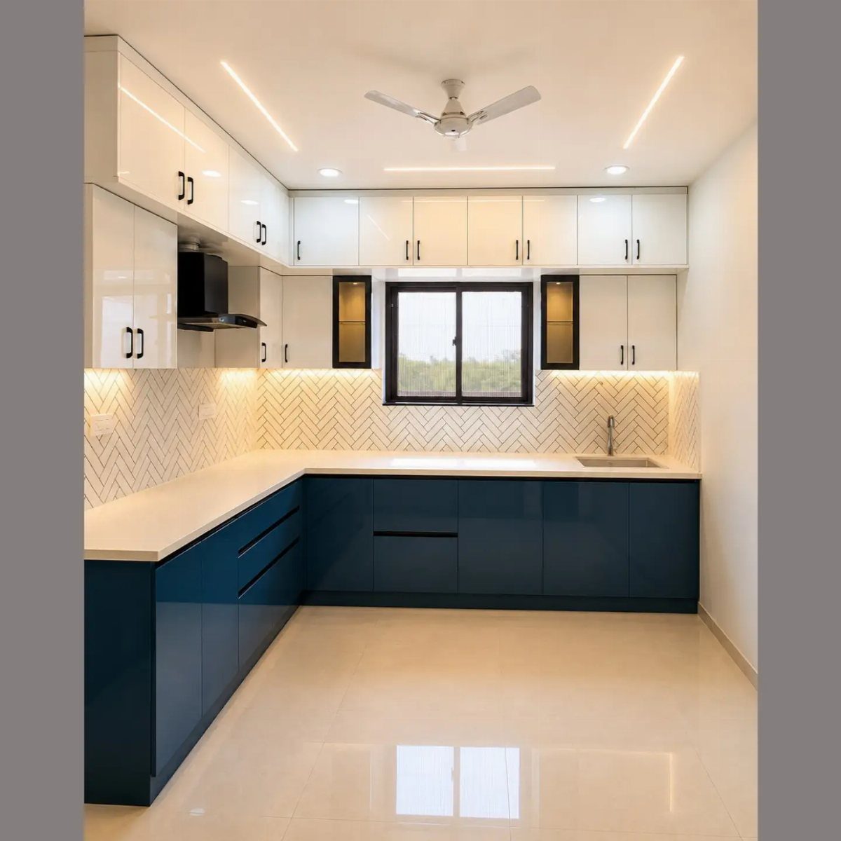 Navy blue lower cabinets and white upper cabinets with under cabinet lighting and backsplash.