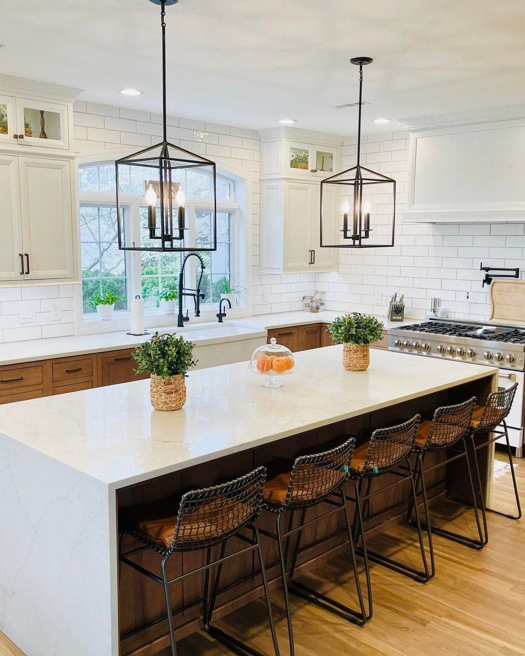 White painted upper cabinets and wood lower cabinets in a bright modern kitchen