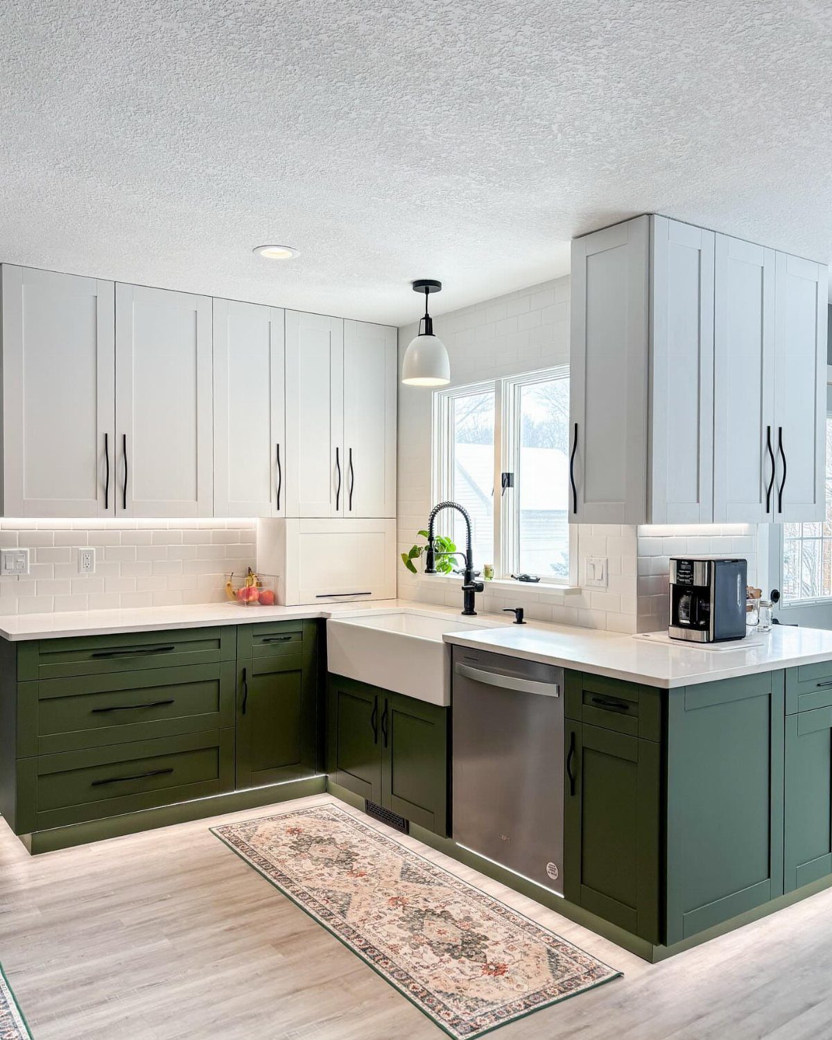 Olive green lower cabinets and white upper cabinets in a bright modern kitchen.