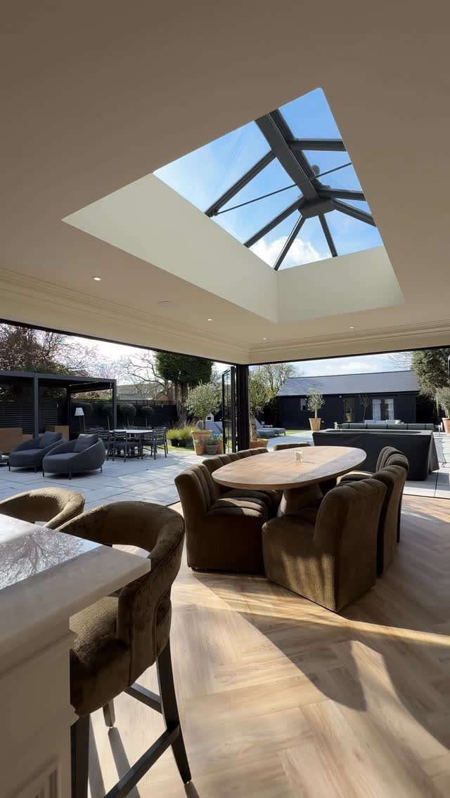 Modern room with large open glass doors and a rectangular ceiling skylight.