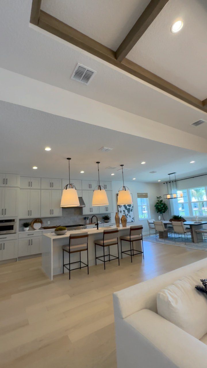 White kitchen island with brown barstools and matching dining chairs in open room