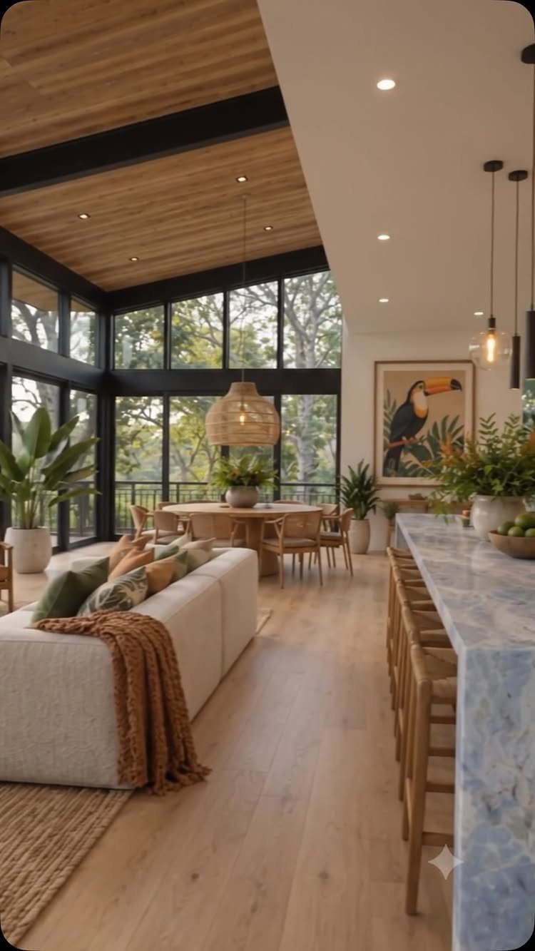 Open living room and kitchen with light wood ceilings, floors, and marble island.