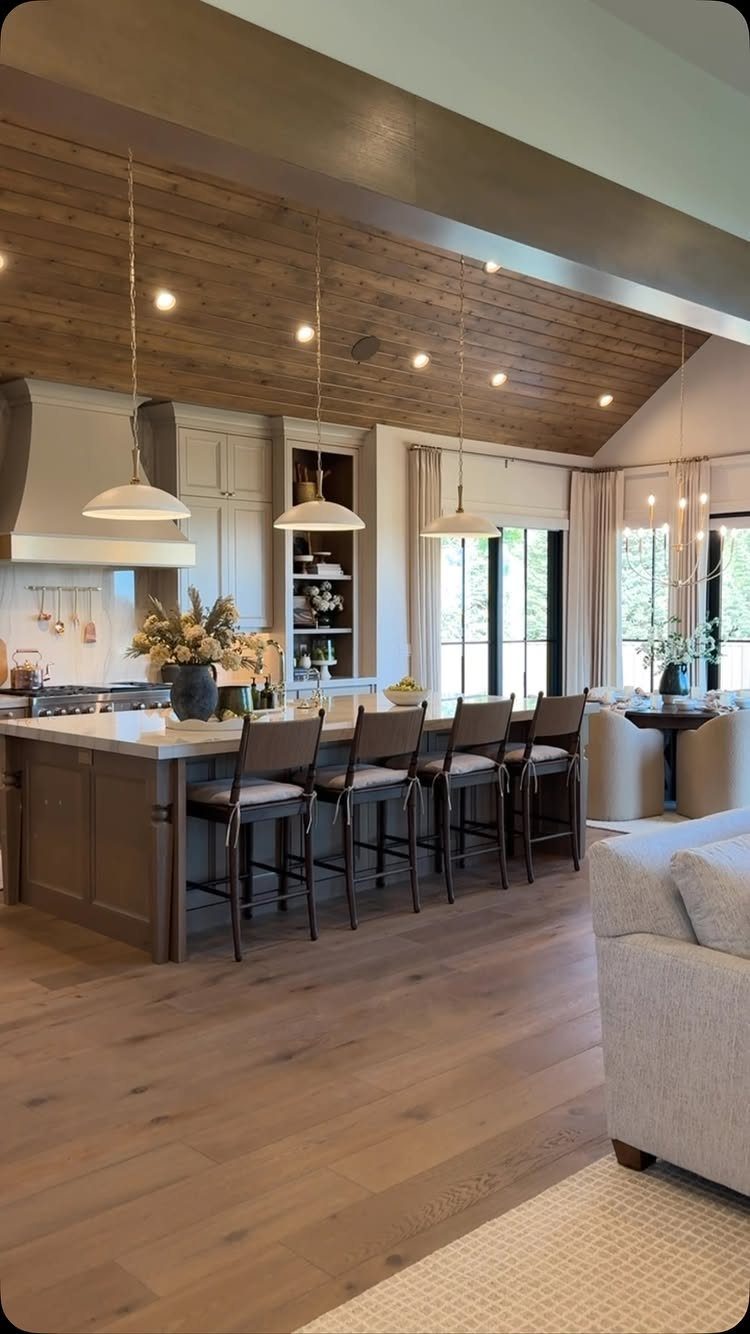 Open concept kitchen and living room with wood ceilings and a large island.