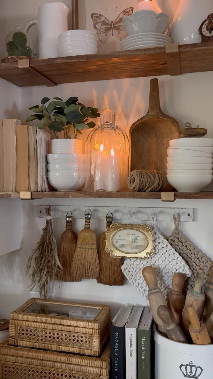Rustic wooden open shelves styled with white ceramics, a plant, and kitchen decor.