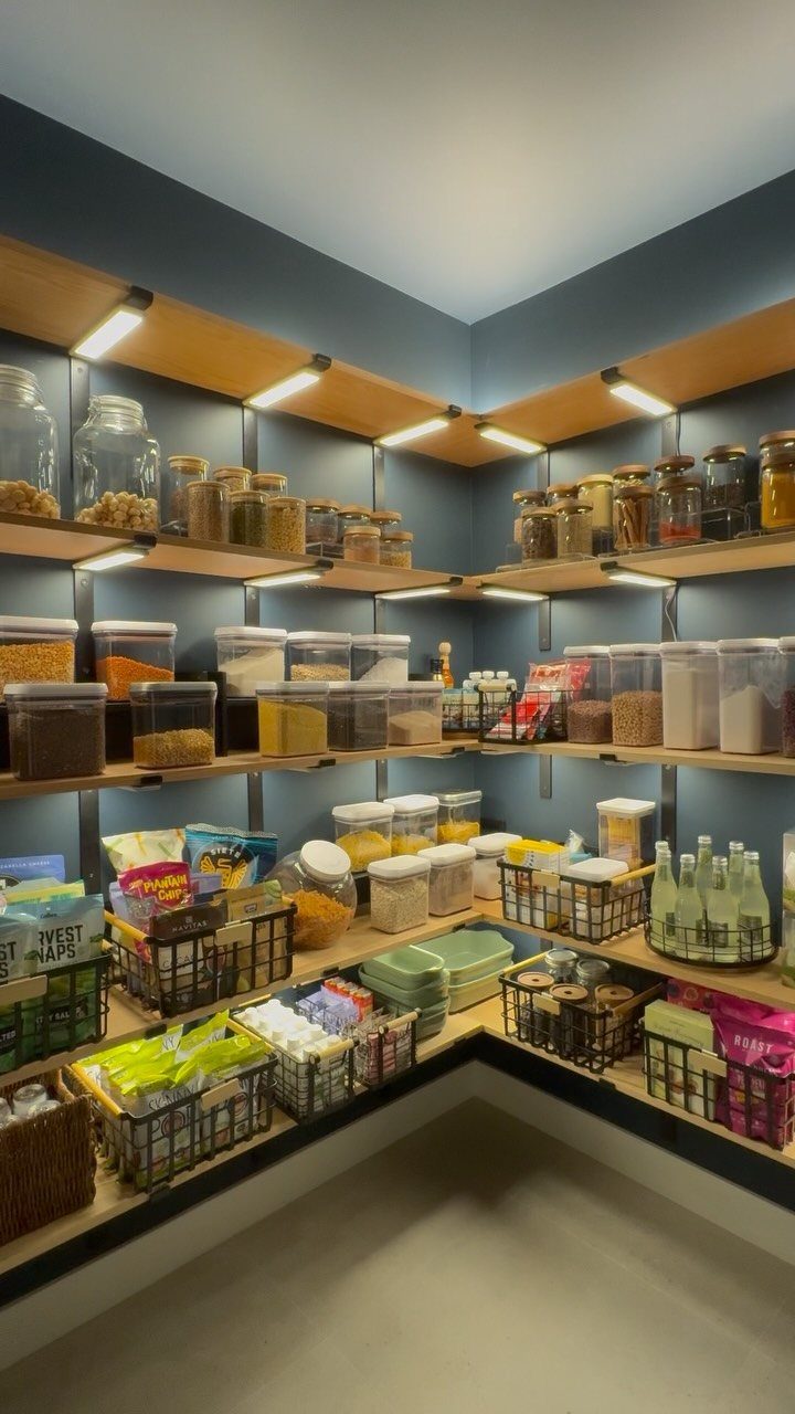 Wooden pantry shelves with integrated under-shelf LED lighting illuminating food storage containers.