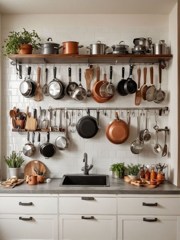 Wooden open shelving and hanging rails with pots and pans in a kitchen