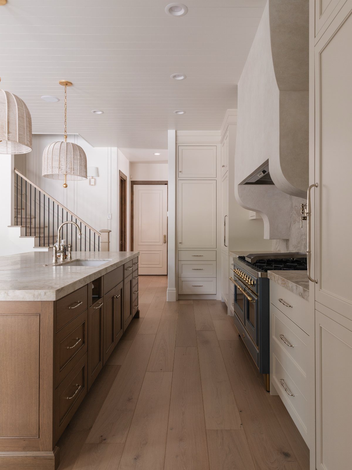 Two-tone kitchen with brown wooden island cabinets and white perimeter cabinetry.