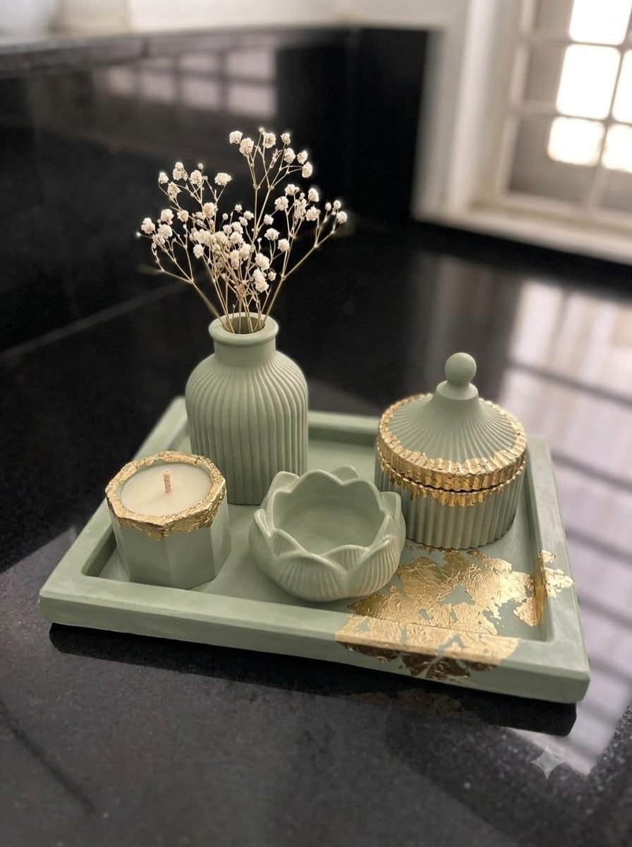 Sage green decorative tray with matching vase, candle holder, and gold-accented jar.