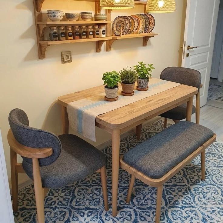 Small wooden dining table with grey chairs and bench on a blue patterned rug.