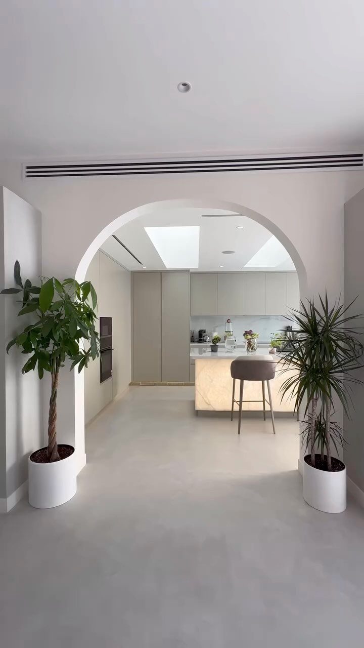 Light grey seamless flooring extending from a living area into a modern kitchen.