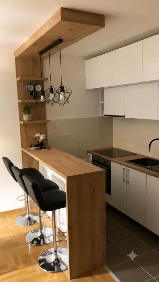 Compact kitchen with white cabinetry and a light wood breakfast bar with black stools