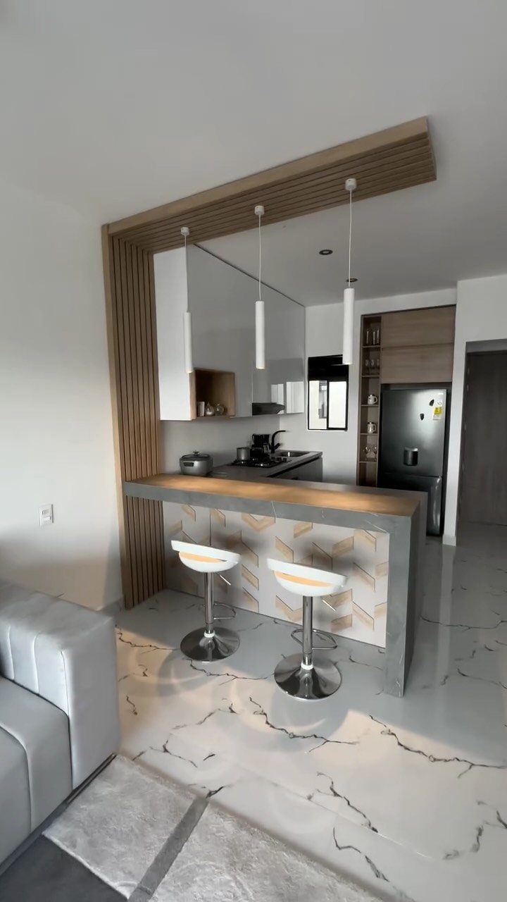 Modern open-concept small living room and kitchen with breakfast bar and marble floors
