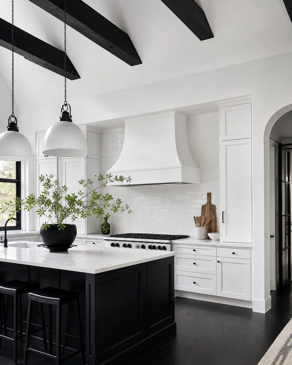 Modern kitchen with white perimeter cabinets and a contrasting black center island.