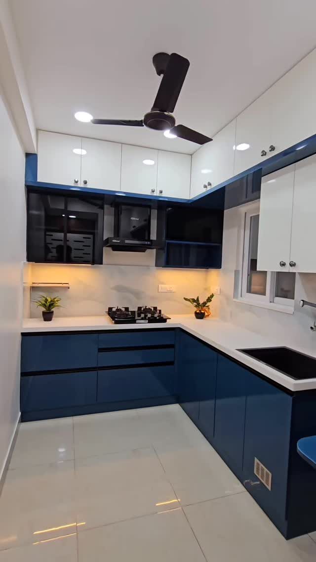 Blue lower cabinets and white upper cabinets in a modern, bright kitchen setting.