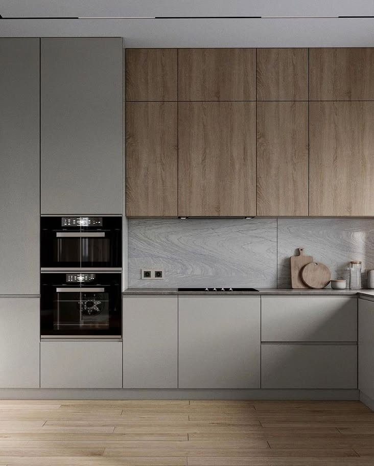 Grey lower cabinets and natural wood upper cabinets in a modern kitchen setting