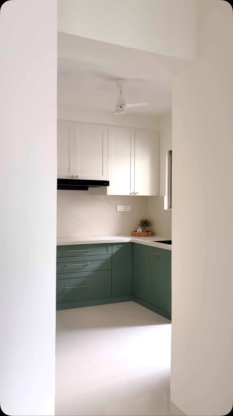Small kitchen with white upper cabinets and sage green lower cabinets.