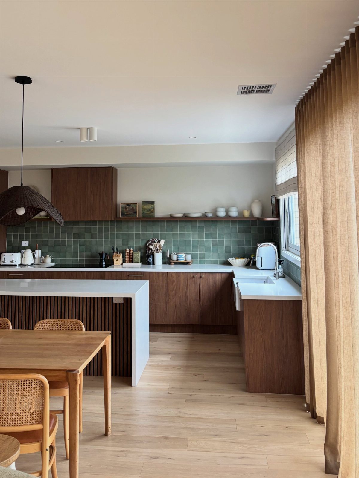 Modern kitchen with dark walnut cabinets, white countertops, and green tile backsplash.