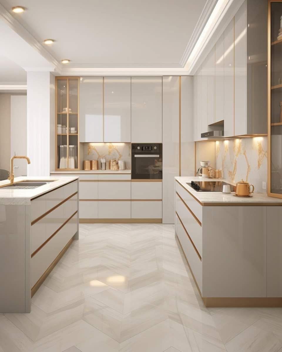 Modern white kitchen with gold trim, glossy cabinets, and herringbone tiled floors.