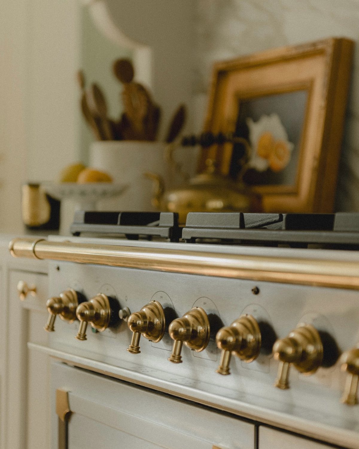 Gold oven knobs on a white stove in a bright kitchen setting