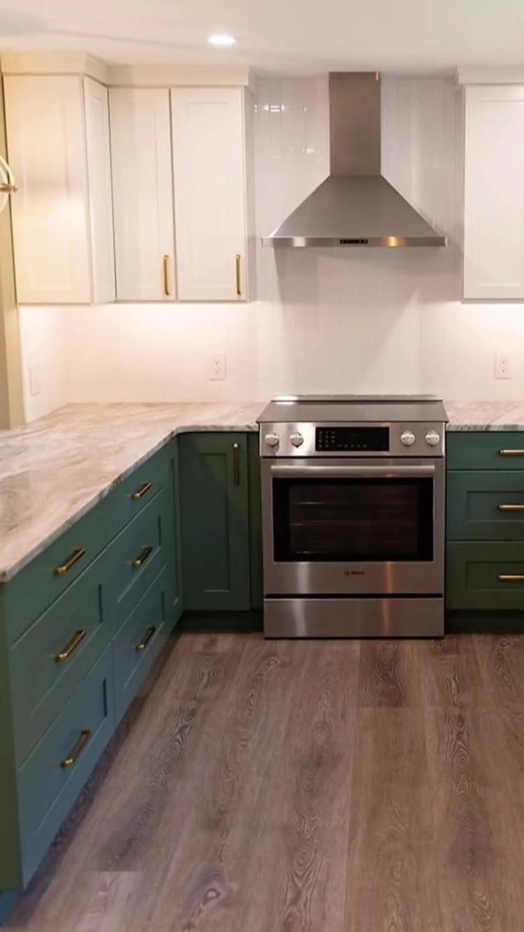 Green lower and white upper kitchen cabinets with gold brass hardware and stainless oven