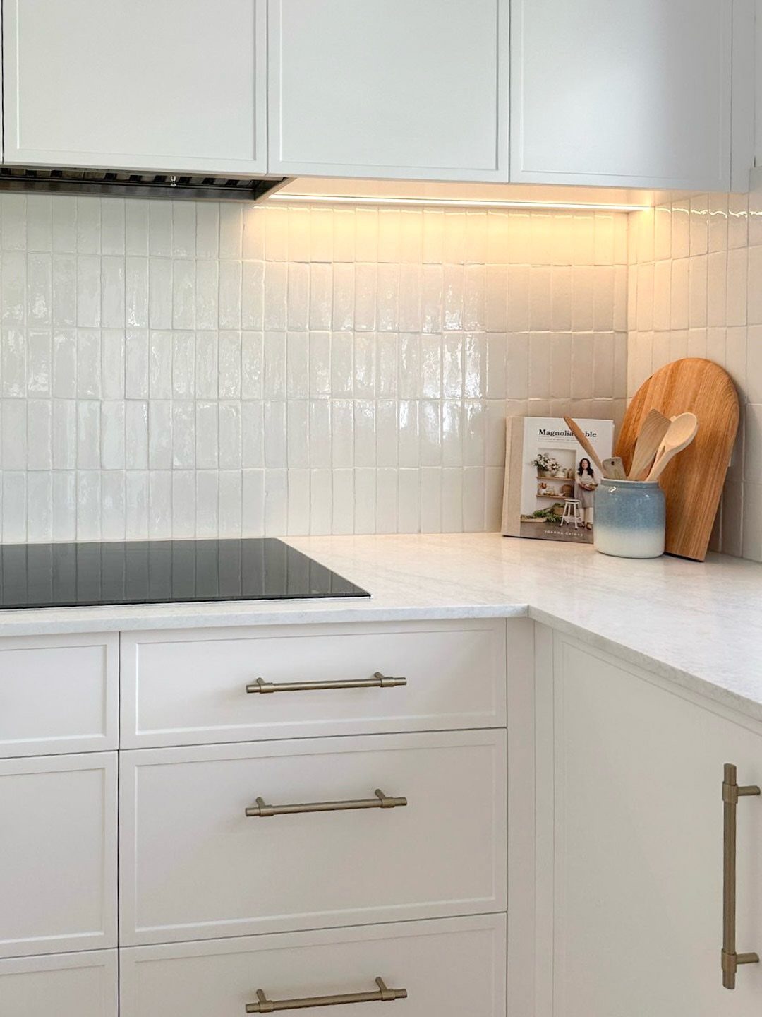 White Zellige-style subway tile backsplash in a bright kitchen with white cabinetry.