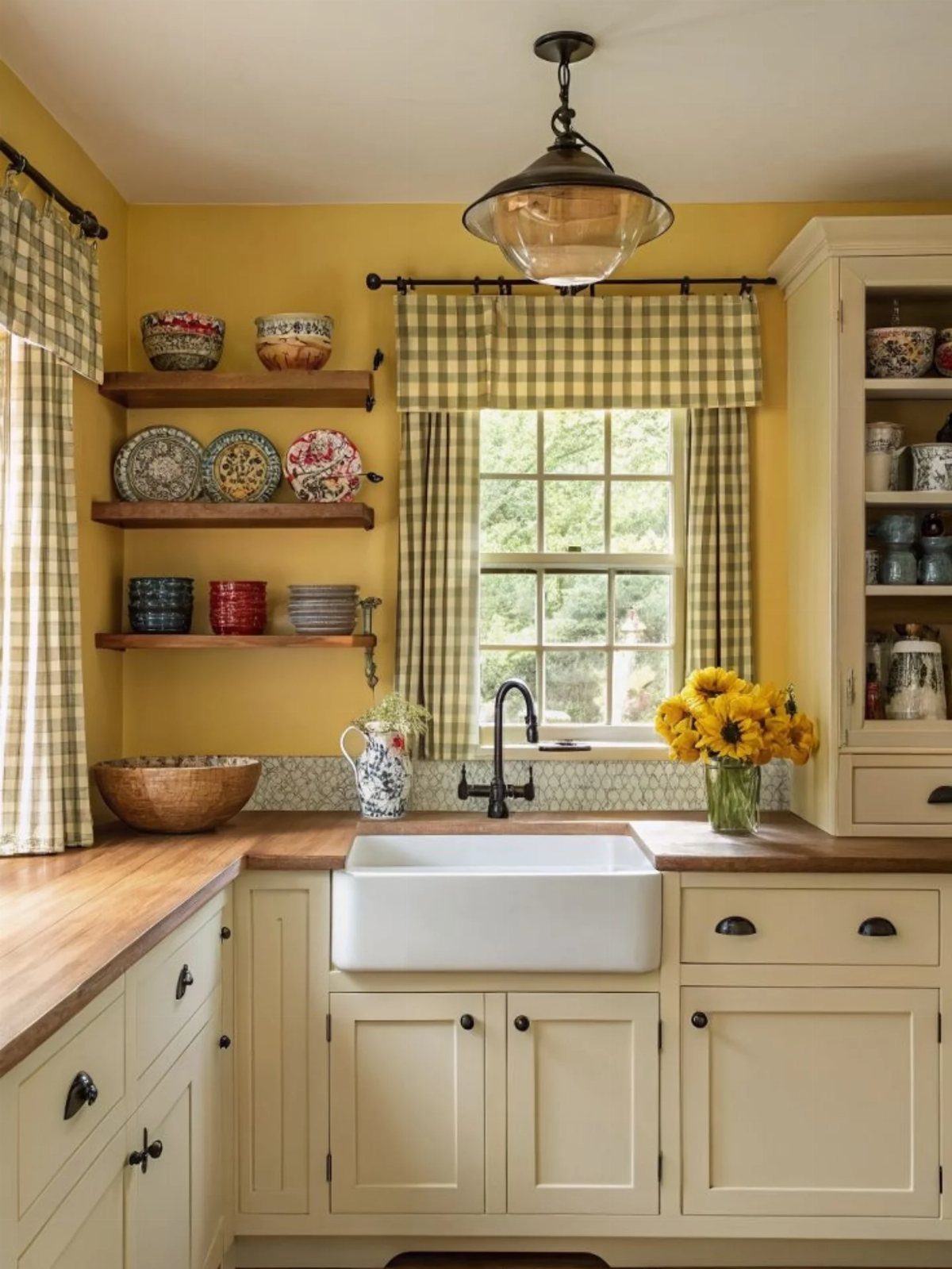 Pale yellow kitchen walls with white cabinets, wooden countertops, and a farmhouse sink.